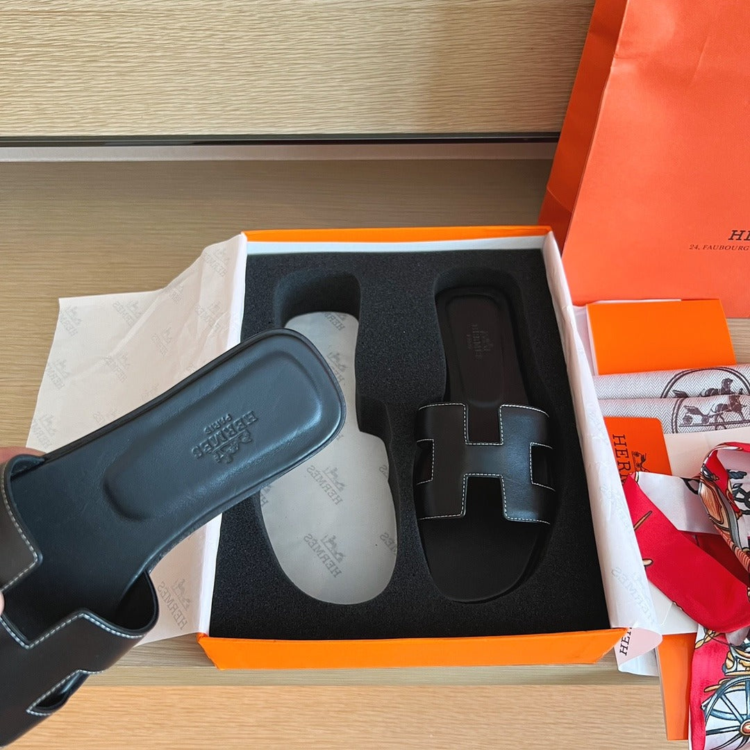 Hermès Oran Sandals in Black Leather with White Contrast Stitching