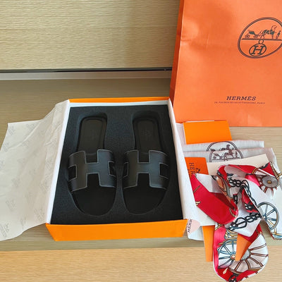 Hermès Oran Sandals in Black Leather with White Contrast Stitching
