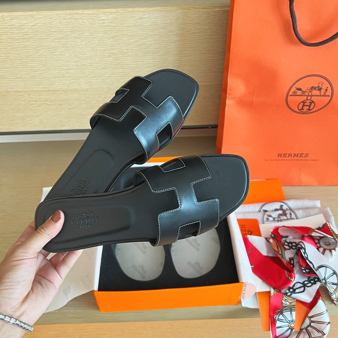 Hermès Oran Sandals in Black Leather with White Contrast Stitching