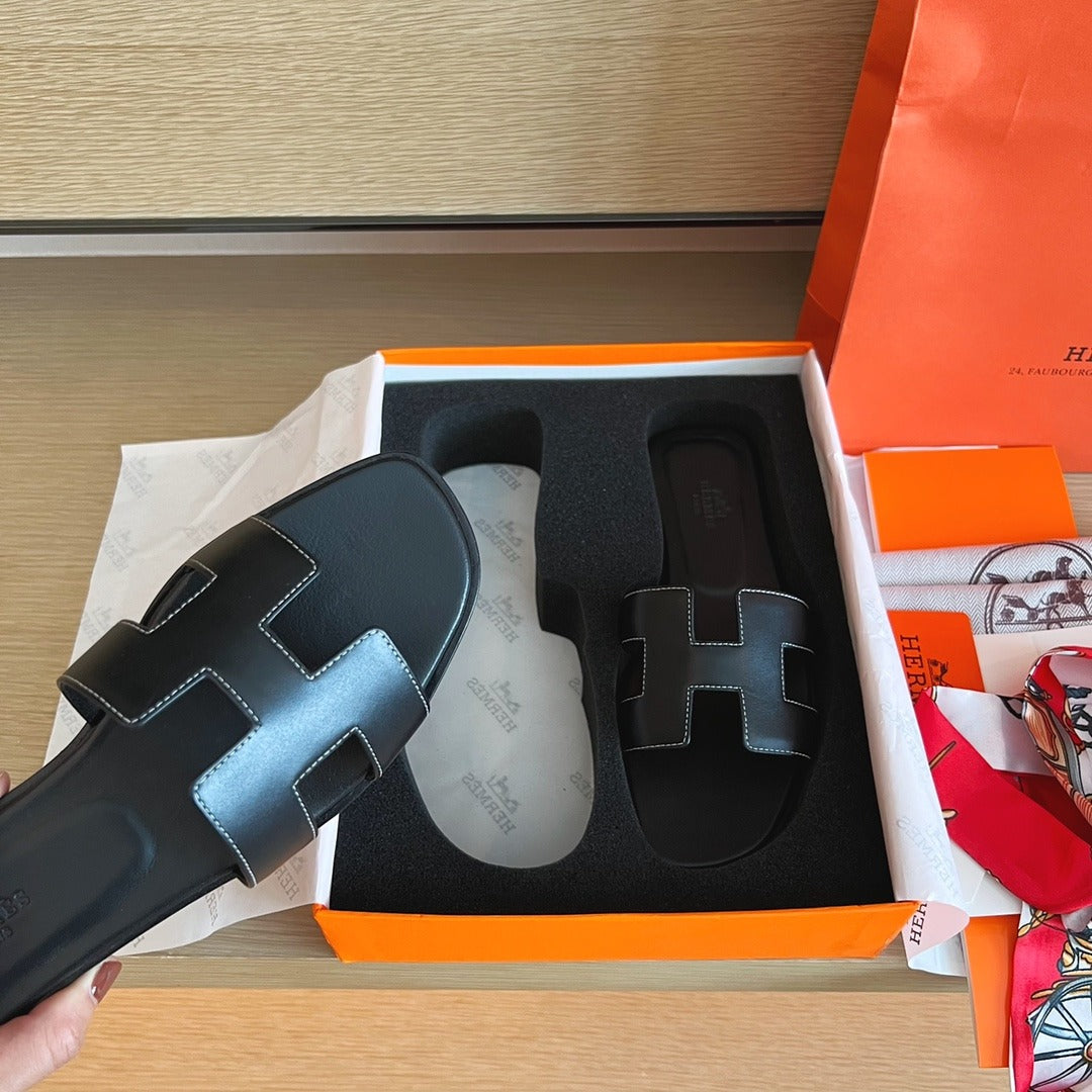 Hermès Oran Sandals in Black Leather with White Contrast Stitching